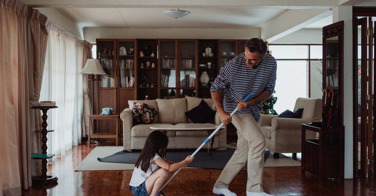 Cleaning a commercial-grade grill surface - Woman in Black and White Striped Long Sleeve Shirt and Gray Pants Holding White Stick