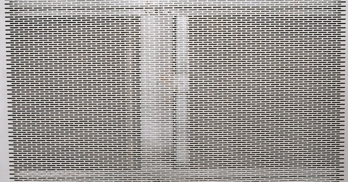 Cleaning a commercial-grade grill surface - Metal gray grill texture with holes