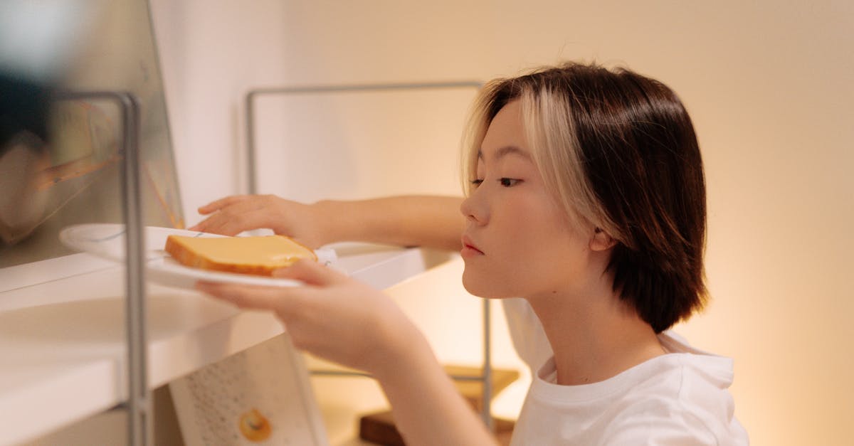 Cleaning a food processor - Woman in White Shirt Cleaning the Book Shelves