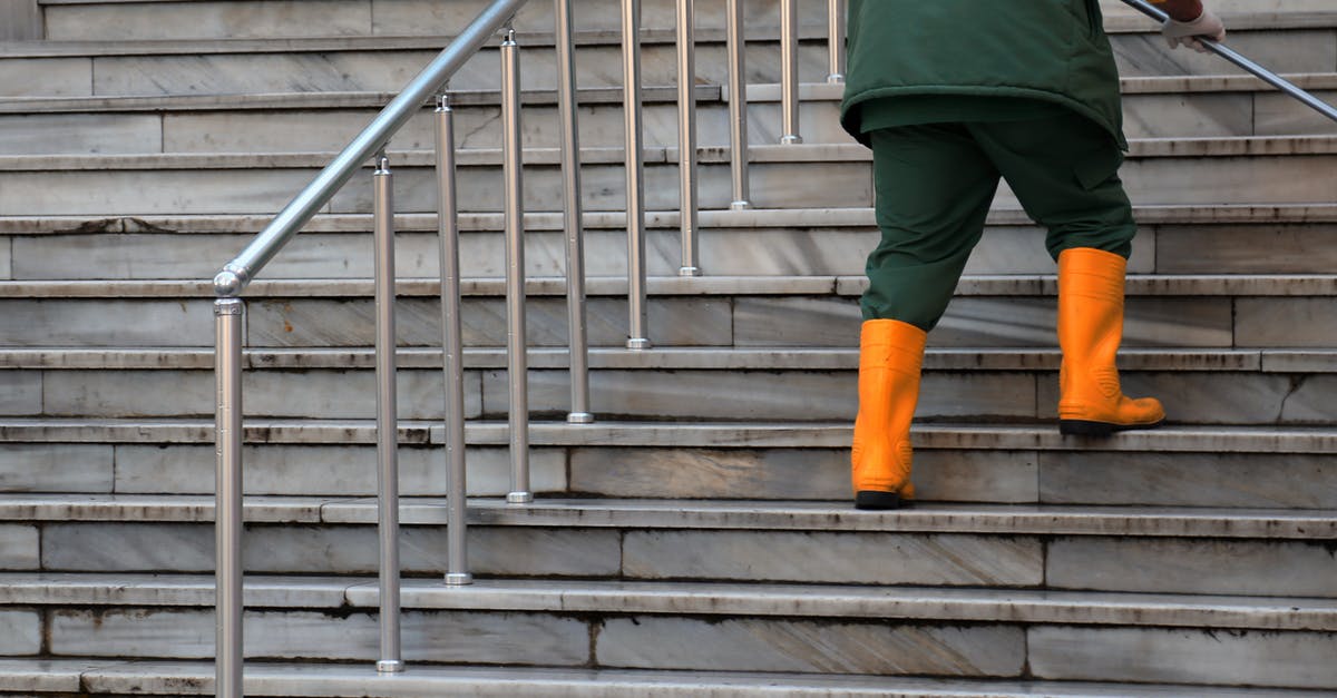 Cleaning burnt-on grease with ammonia - Person in Green Jacket and Brown Pants Walking on Gray Concrete Stairs