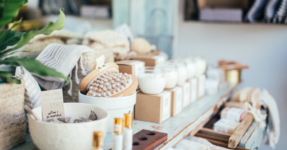 Cleaning out a smell - Many fragrant candles placed near massage brushes and perfume in shop for sale