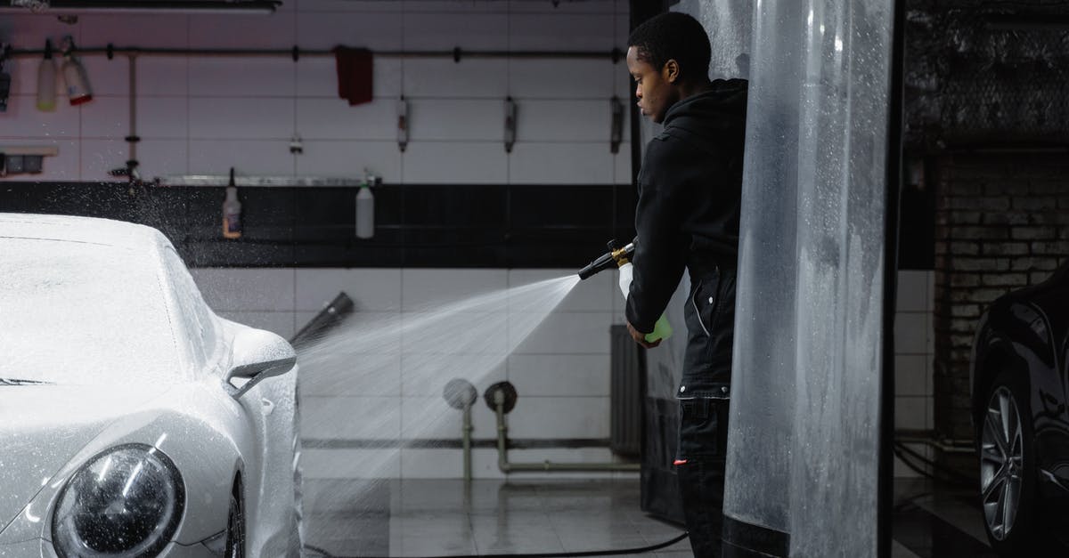 Cleaning pressure cookers advice - Man in Black Jacket Washing the White Car Using a Washer Pressure Hose