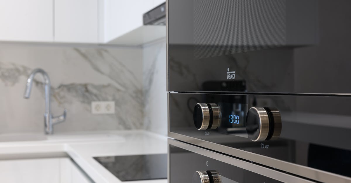 Cleaning white bubbles on induction stove - Interior of contemporary kitchen with stainless white surface induction cooker and electronic stove in modern apartment