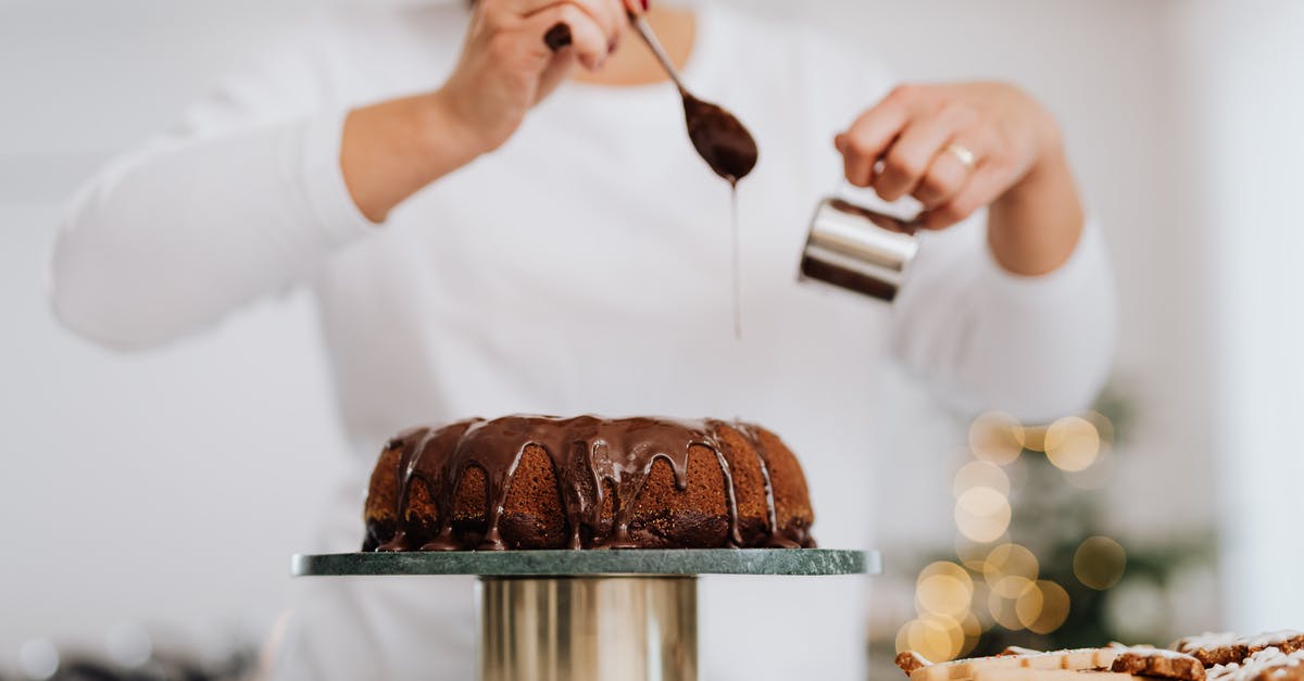 Coating fruit before adding to a cake - Person Holding Stainless Steel Cup and Spoon