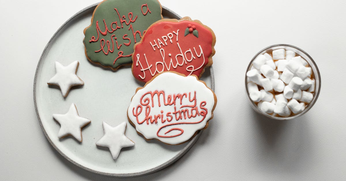 Cocoa butter crystals in chocolate frosting - Overhead composition of traditional Christmas desserts gingerbread cookies with colorful frosting and painted wishes together with star shaped cookies placed near hot chocolate with marshmallows