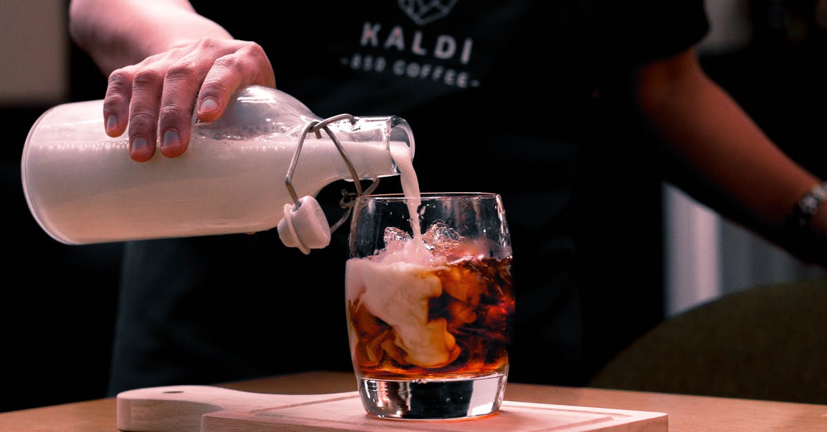 Coconut milk in iced coffee - Photo Of Person Pouring Milk On Glass