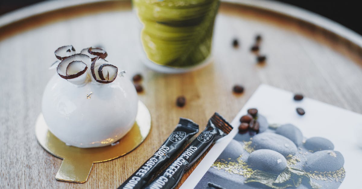 Coconut rice; should it taste like coconut? - From above of tasty coconut glazed cake garnished with coconut shaving served with takeaway coffee and sugar sticks and coffee beans on round cafe table