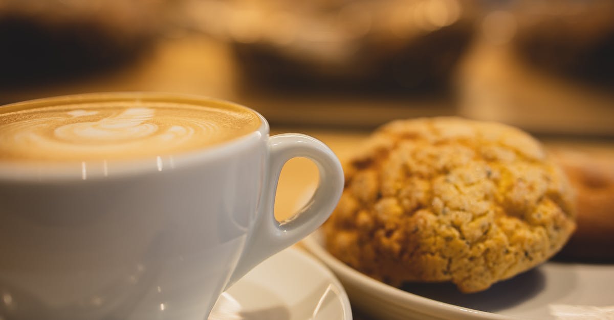 Coffee Biscuit doesn't come out in Knock Box - Mug of tasty fragrant coffee with latte art served near plate with oatmeal cookies on table on blurred background