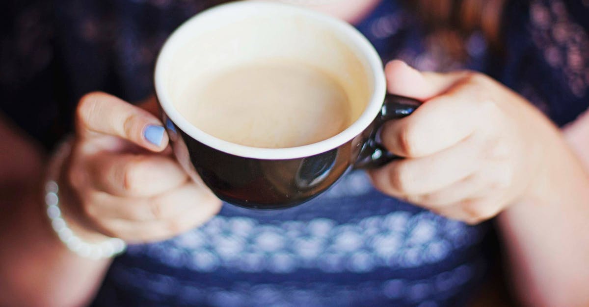 Coffee foam vs. Tea foam - Person Holding Black and White Ceramic Mug