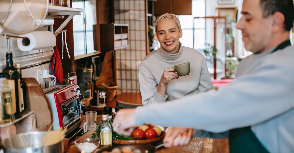 Coffee in a rattlesnake recipe? Why? - Male seasoning delicious meatballs in pan against cheerful female beloved with cup of coffee in kitchen