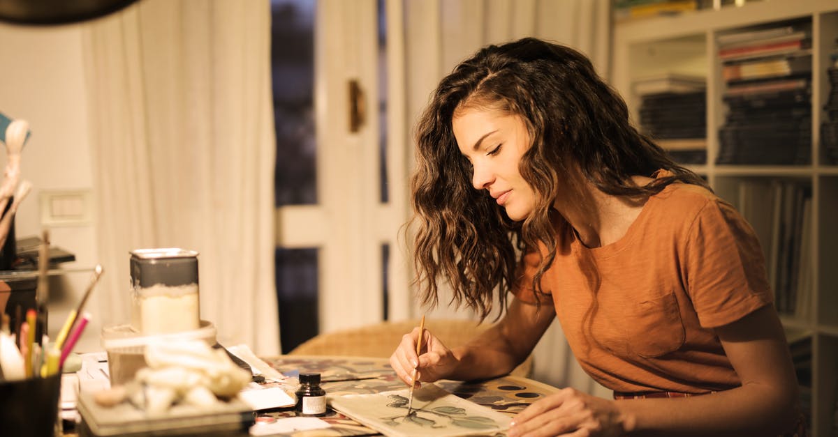 Coffee Soluability/Concentration - Young woman painting on paper at workplace