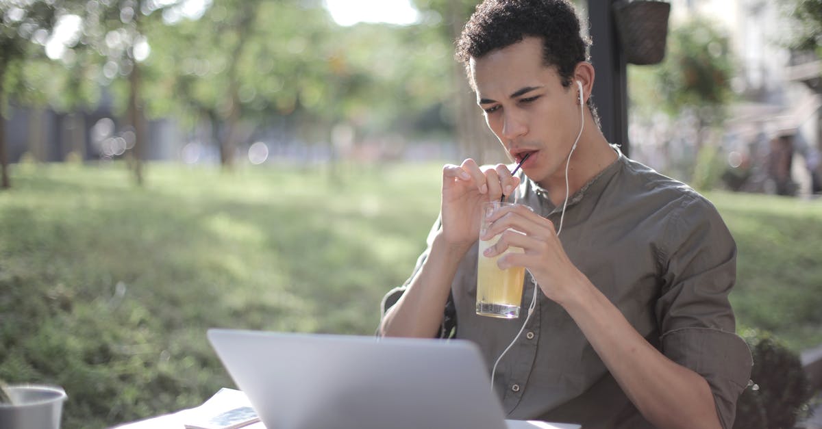 Cold Brewing coffee - does it use more beans? - Black man drinking lemonade in cafe and using laptop