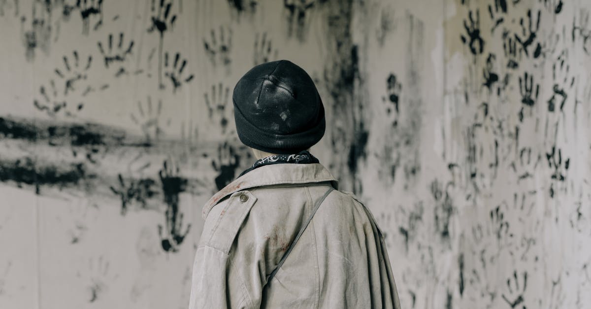 Collapsing soufflé - Person in Brown Coat and Black Hat Standing Near White and Black Floral Wall