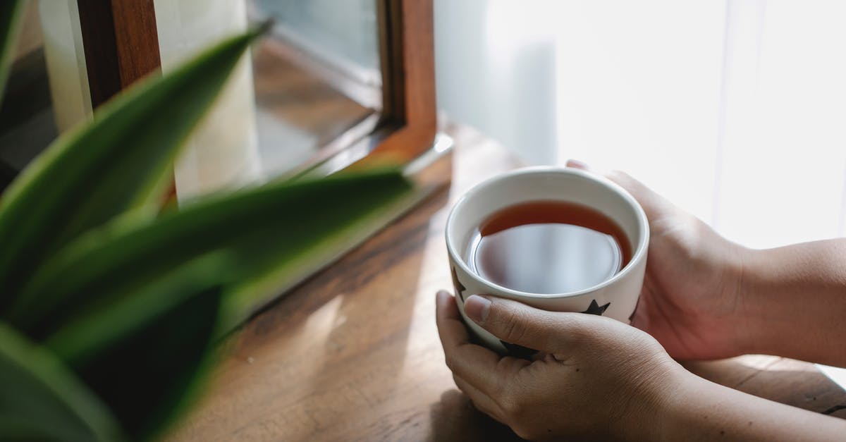 Combining hot melted sugar with cold liquid ingredients - Crop person with cup of tea