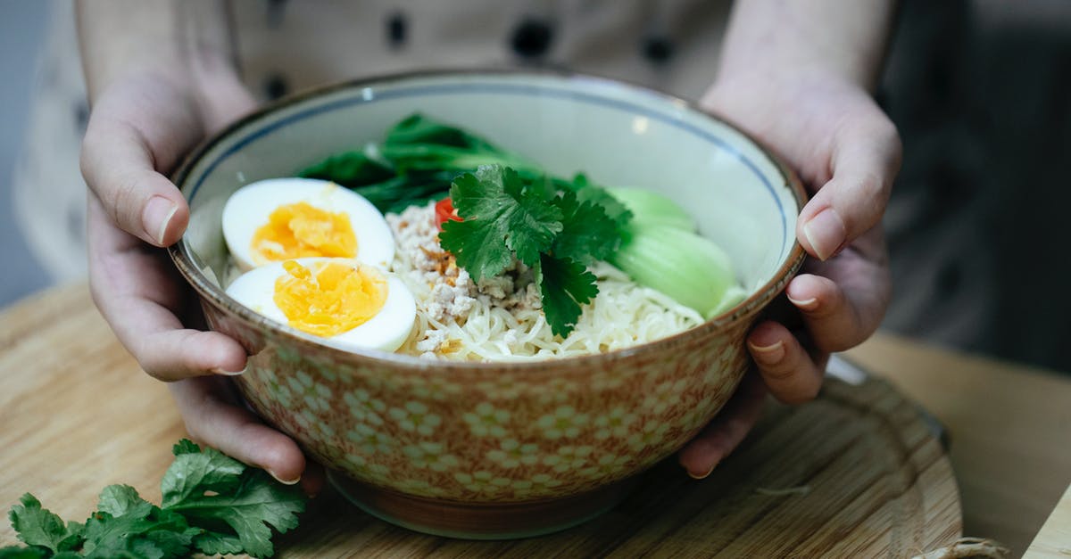 Common ingredient to thicken the soup - Crop unrecognizable woman touching bowl with traditional ramen soup