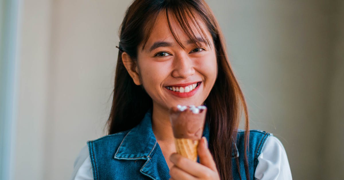 Complementary taste to elderberry ice cream? [closed] - Delighted Asian woman with ice cream cone