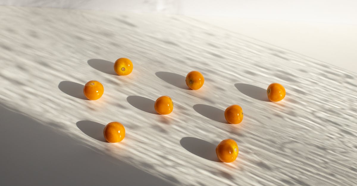 Composition/safety of cherry pits - Sweet yellow ripe cherry tomatoes arranged on white surface in shadows in light studio