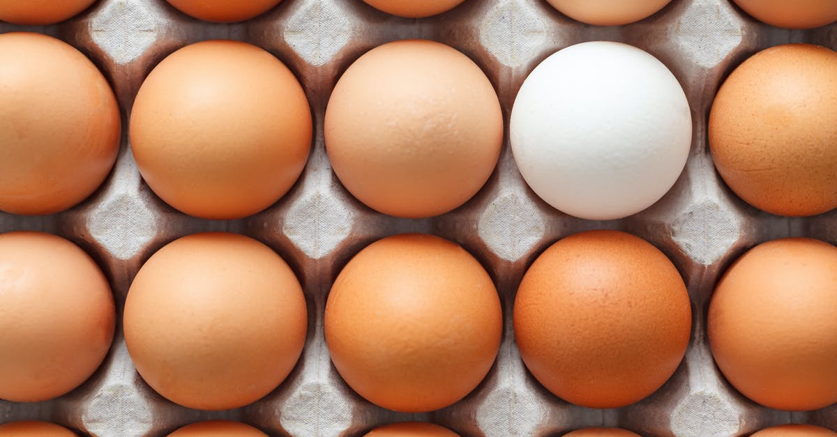 Conflicting instructions from different sources: roasting chicken - Top view of rows of uncooked chicken eggs placed in carton container and prepared for cooking