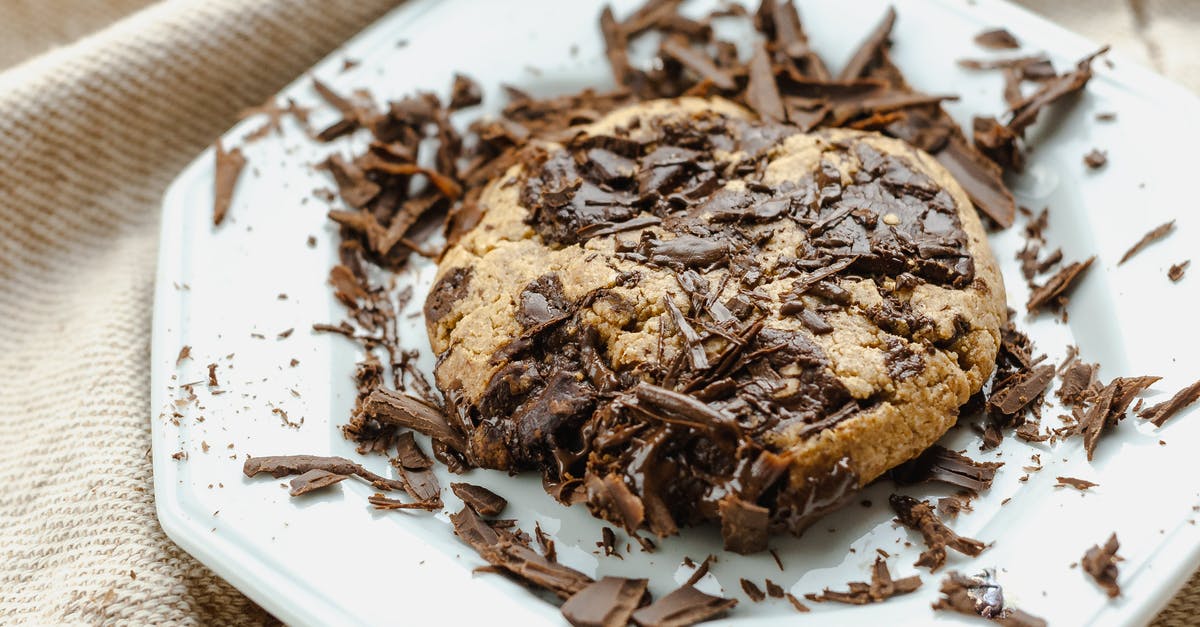 Convert chocolate chip cookie recipe to chocolate chocolate chip cookie - High angle of tasty homemade cookie with chocolate pieces on white ceramic plate