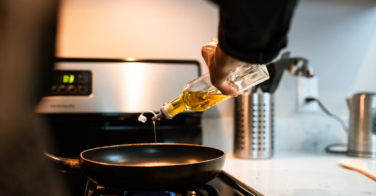 Convert grill recipe to broiler and/or oven - Back view crop unrecognizable person pouring olive or sunflower oil into frying pan placed on stove in domestic kitchen