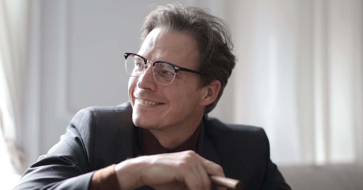 Converting upright charcoal smoker to electric - Photo of Smiling Man in Black Suit and Black Framed Eyeglasses Sitting on White Couch Smoking a Cigar