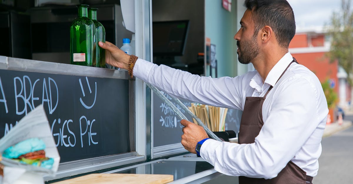 Cook Time vs. Cook Temp trade off - Focused ethnic male worker placing glass bottle at counter