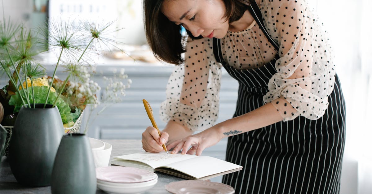 Cookbook on Odisha cuisine - Woman Wearing a Apron Writing on a Notebook