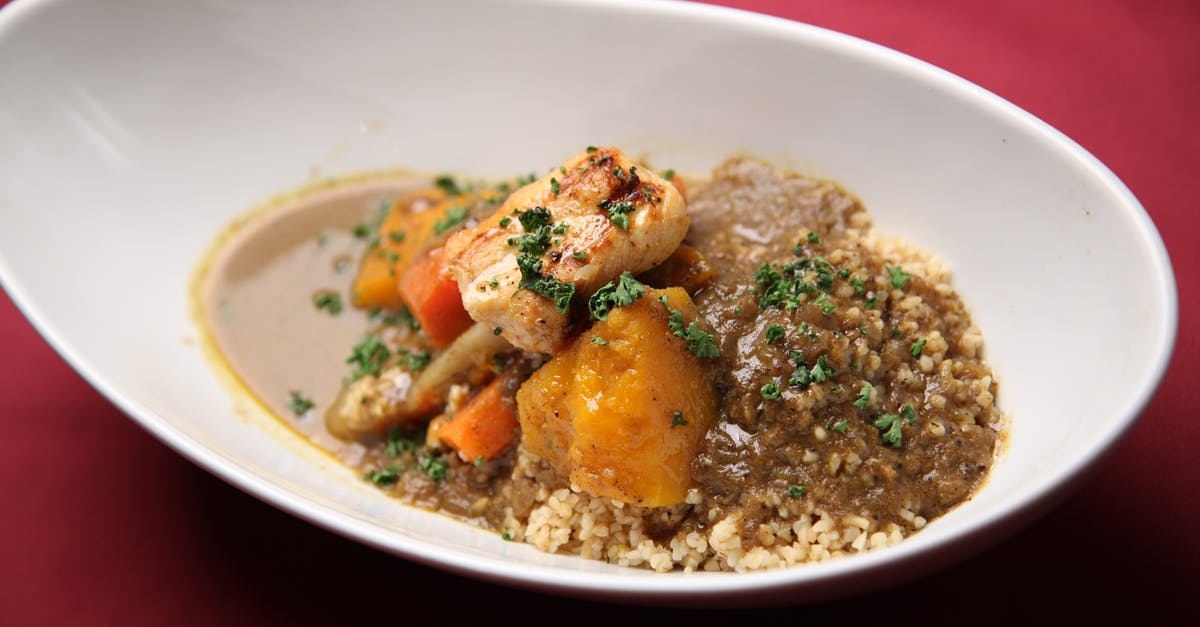 Cooking a chicken and vegetable curry using a curry paste - White Ceramic Bowl on Red Textile