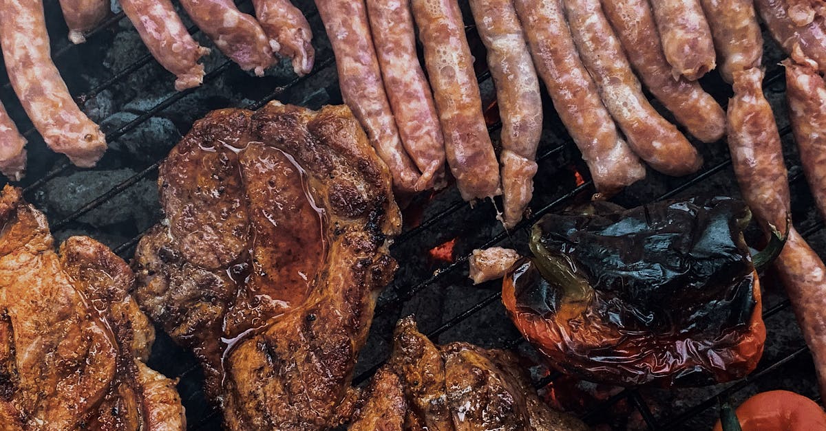 Cooking a large pork roast in a slow cooker - From above yummy steaks and meat sausages roasting on grill grid near organic capsicum during picnic