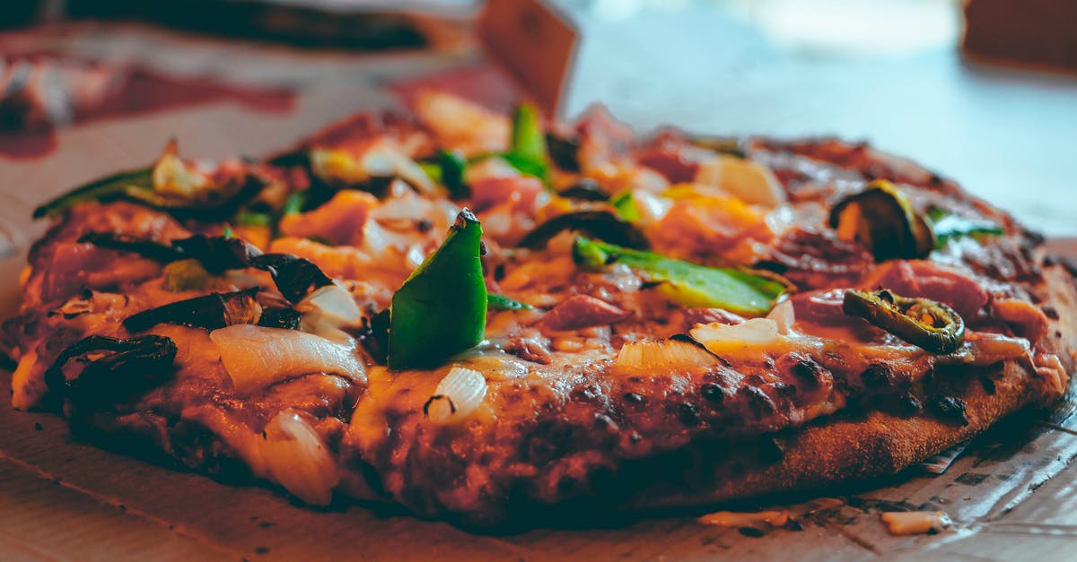 Cooking a whole 30lb sturgeon on a spit - Selective Focus Photography of Baked Pizza