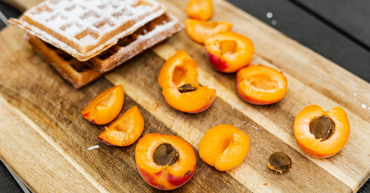 Cooking Belgian Waffles in waffle iron - Sliced Orange Fruit on Brown Wooden Chopping Board