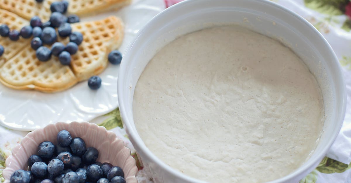 Cooking Belgian Waffles in waffle iron - White Plastic Container With Black Beans