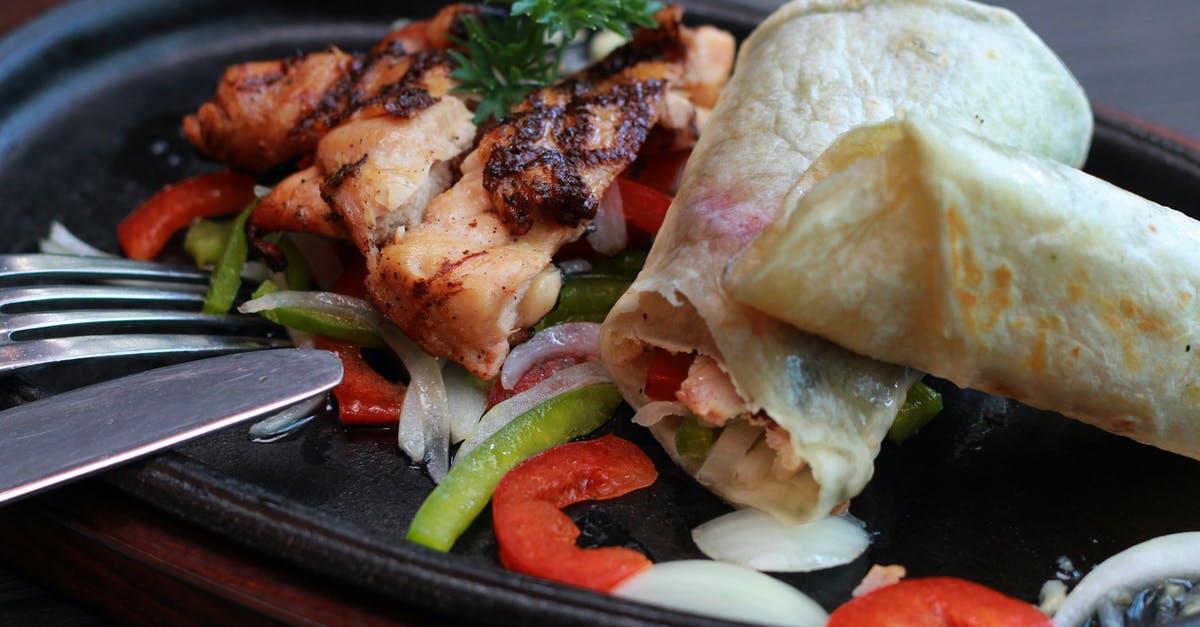 Cooking chicken breasts in Buffalo sauce, cast iron - Meats and Vegetables on Black Oval Sizzling Plate