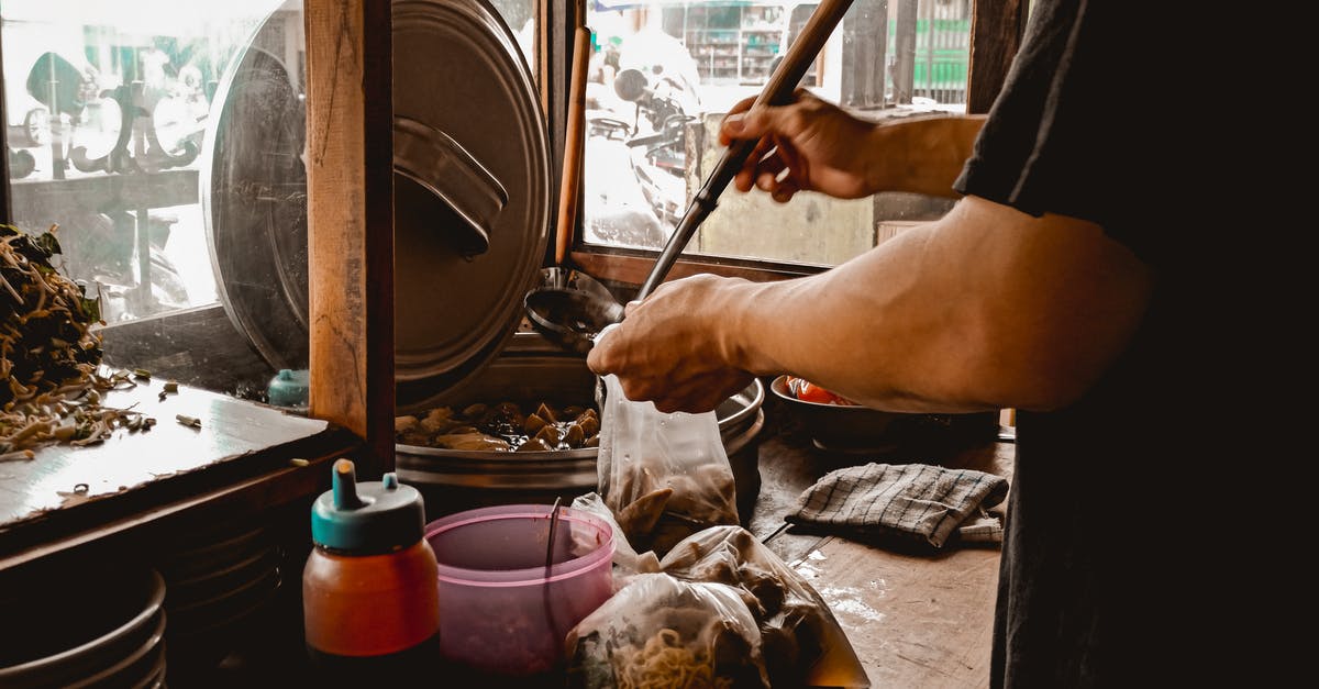 cooking in a plastic bag without removing extra air, at 100c? - Man pouring soup in plastic bag while preparing Asian food