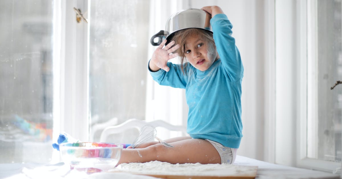 Cooking in painted metal pots - Little girl playing with pan and flour in kitchen