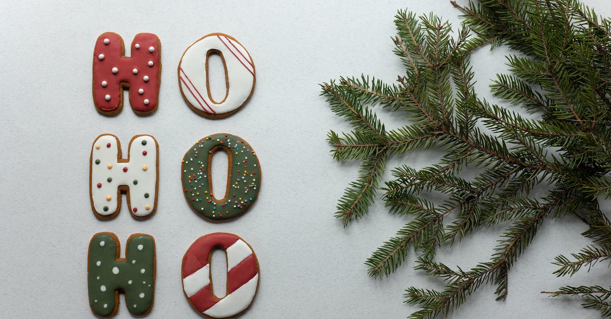 Cooking "purple sweet potatoes" or "purple yams" - From above of Christmas composition with gingerbread cookies with Ho Ho Ho letters and fir tree branch on white table