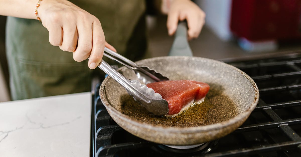 Cooking steak in frying pan, problem with oil splatter - Cook Frying Slice of Red Tuna Fish Meat on Gas Cooker