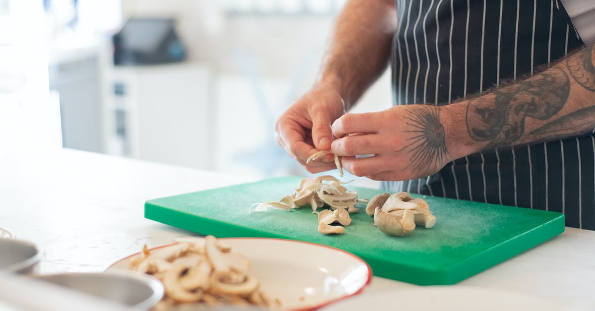 Cooking with a cut or burn on my hands - Man in Striped Apron Peeling Mushrooms on Green Chopping Board