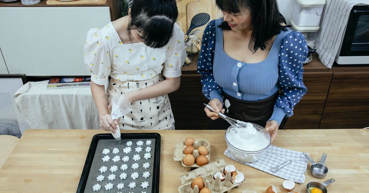 Cooking with sugar makes pan very difficult to clean - From above content Asian housewives wearing stylish outfits and aprons using piping bag to form meringue cookies on baking pan in modern kitchen