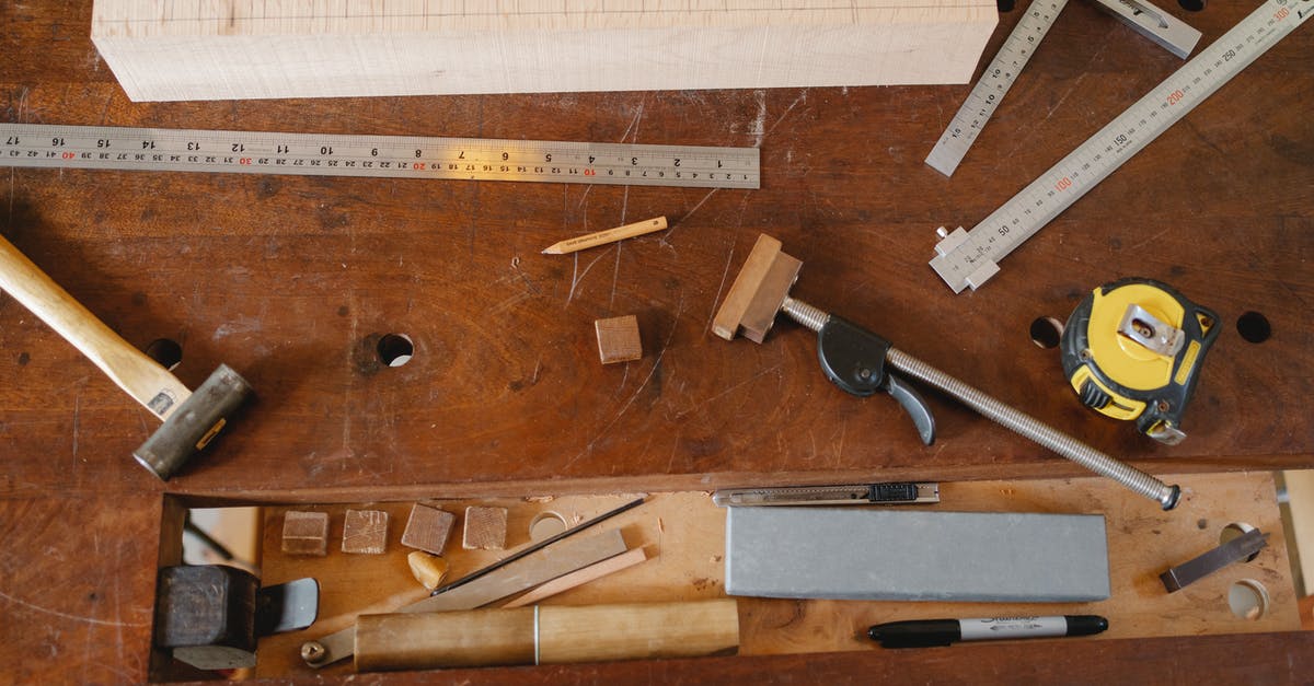Cookware, copper or cast iron or just buy the right tool for the job? - Top view of various equipment for joinery and measuring placed on timber table