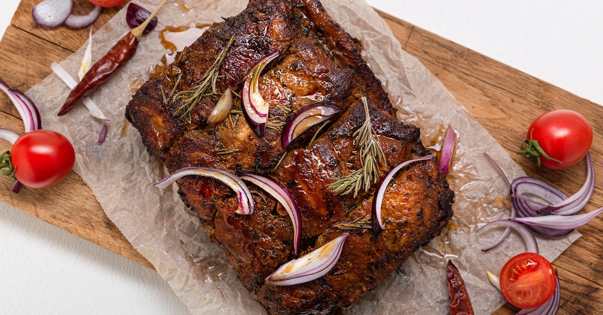 Cooling a Roast cooked in a Crockpot - Cooked Meat on Baking Paper on a Wooden Board