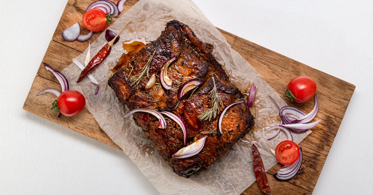 Cooling a Roast cooked in a Crockpot - Cooked Meat With Herbs and Spices on a Wooden Board