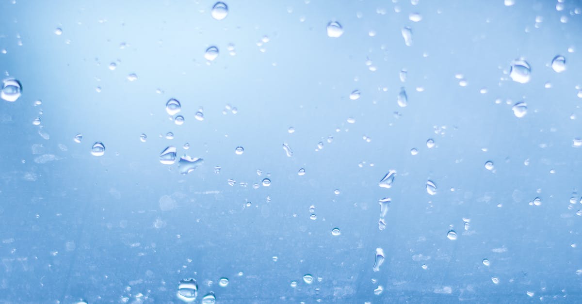 Cooling and diluting over-reduced stock down with cold water - Close-up of Water Droplets Against Blue Background