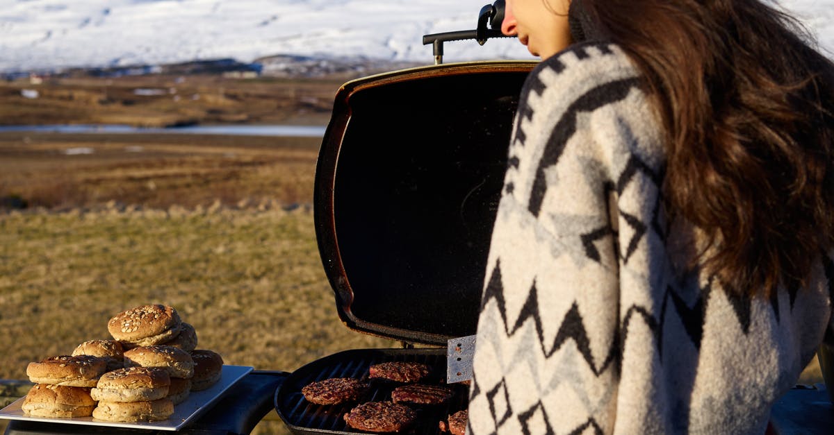 Cooling off a kettle-style grill - Young woman near portable BBQ in countryside