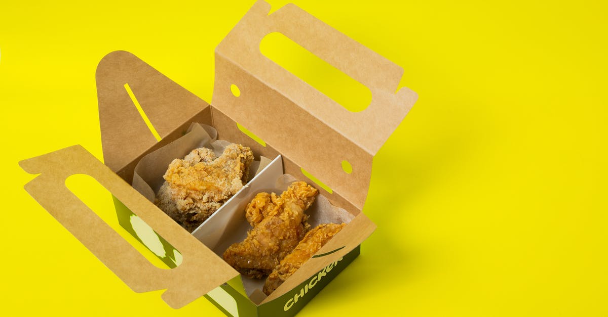 cornmeal crust on chicken is too gritty, is there a way to fix after chx has been baked? - From above of opened cardboard box with takeaway fried chicken meat placed on bright yellow surface in studio