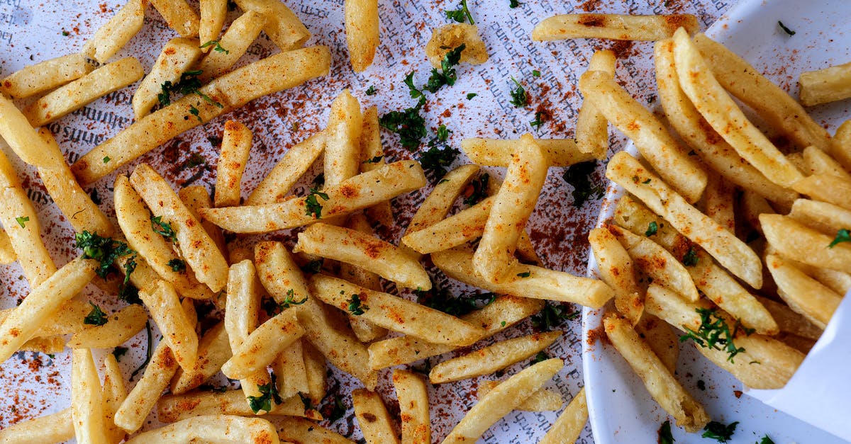 Corn/Potato/Rice/Flour starches in deep frying - Heap of delicious crunchy fried potatoes spilled on table