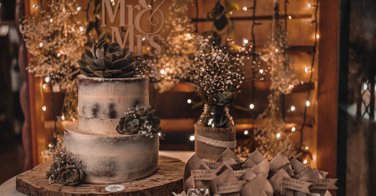 Correct temperature to serve a chocolate gateau (cake) - Wedding cake placed on wooden board near glass bottle with fresh blooming delicate flowers