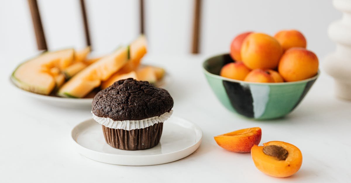 Correct temperature to serve a chocolate gateau (cake) - Halved ripe apricot near chocolate cupcake and assorted fruits on background