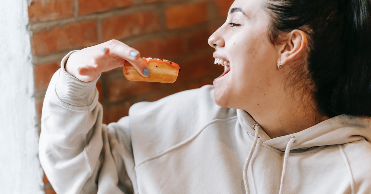 Correlation between perceived sweetness and sugar content - Crop excited woman eating fresh yummy donut