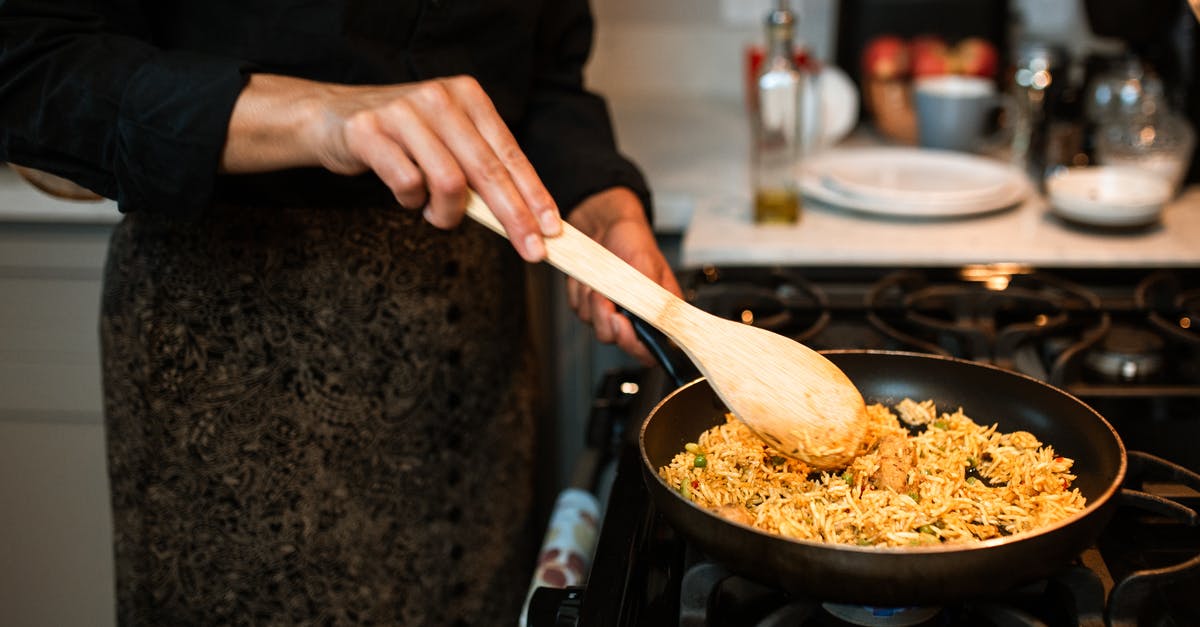 Could I use orzo instead of paella Rice? - A Person Cooking a Rice Dish